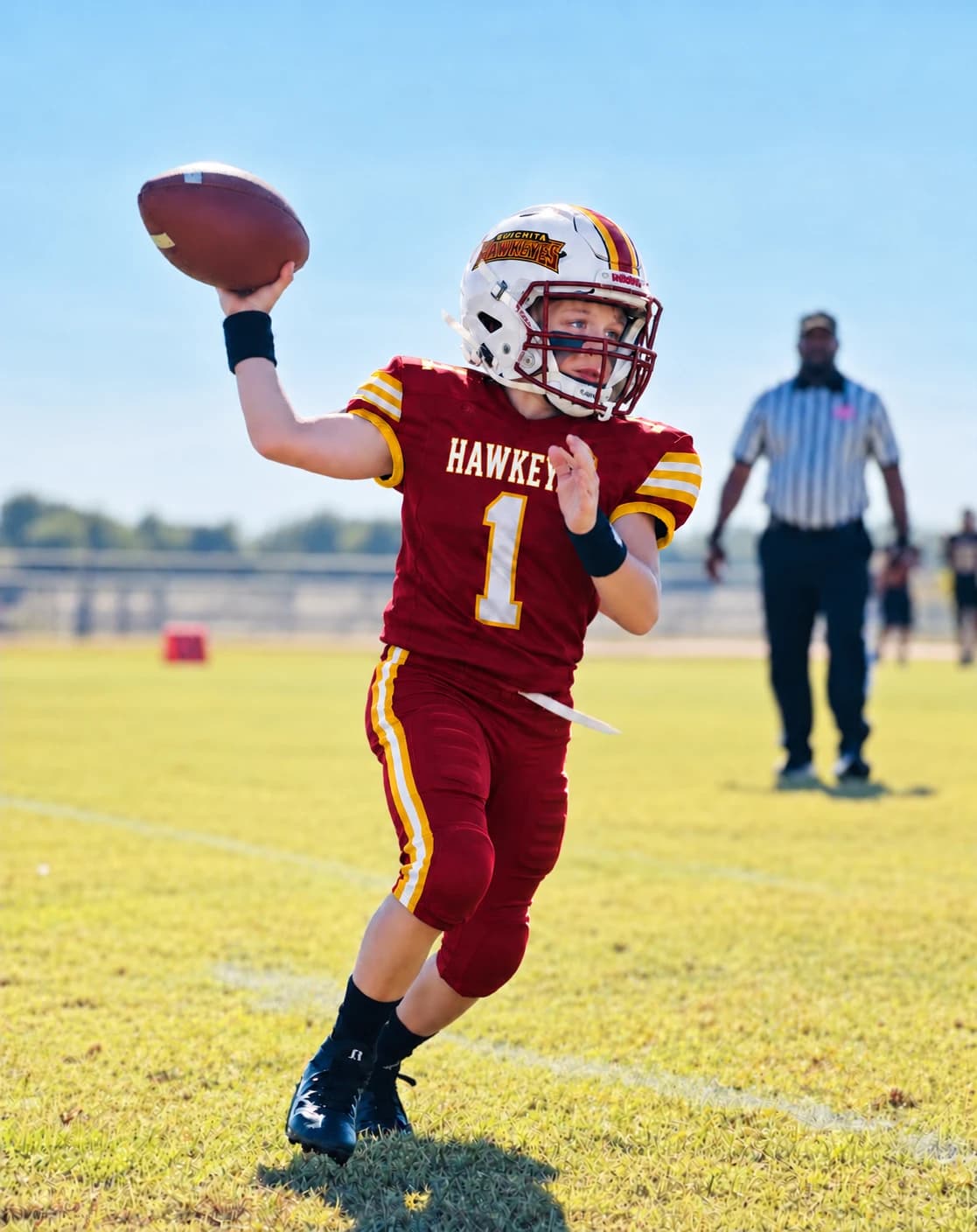 Ouachita Hawkeyes quarterback in the maroon home uniform throwing a pass